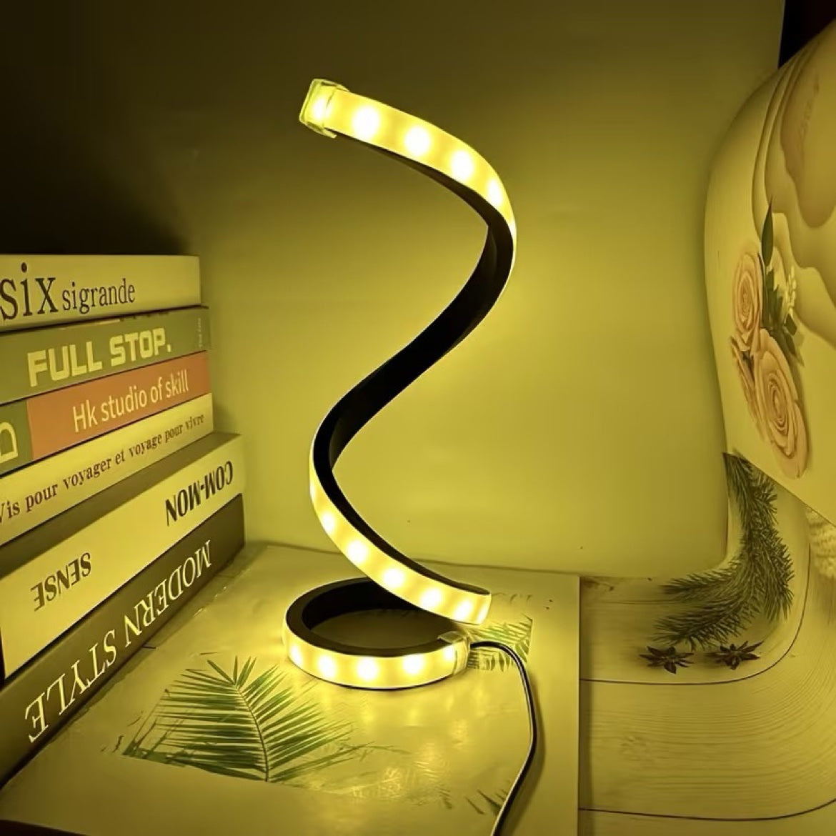 Spiral LED lamp warm light beside books